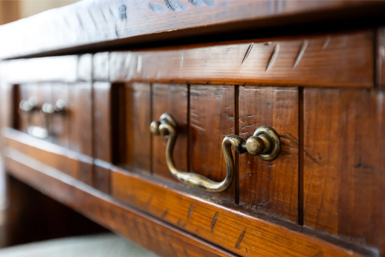 imagen de plano de talle del cajón de un mueble antiguo con tirador dorado desgastado